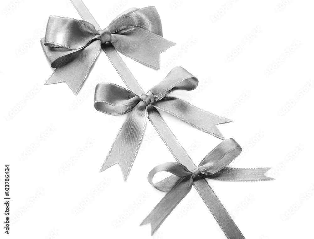 Silver silk ribbon with beautiful bows isolated on white background Silver silk ribbon with beautiful bows isolated on white background