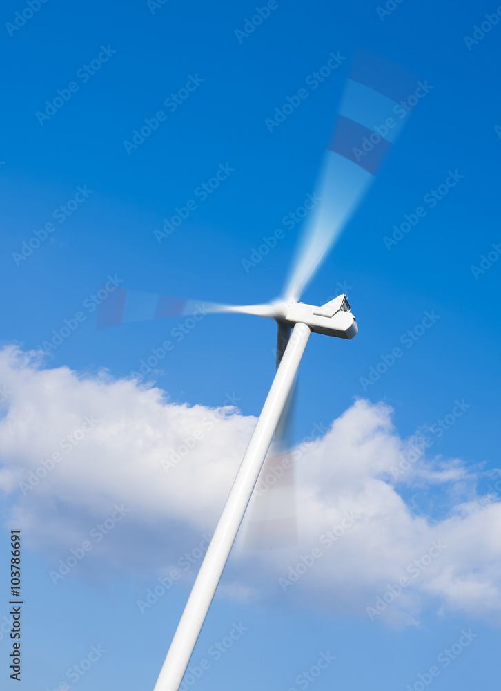 Close up of white wind turbine generating electricity on blue sky. Alternative energy concept Close up of white wind turbine generating electricity on blue sky. Alternative energy concept