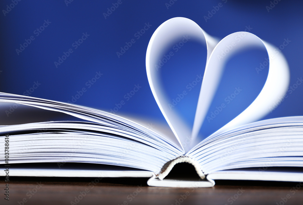 Heart from book pages on blue blurred background Heart from book pages on blue blurred background