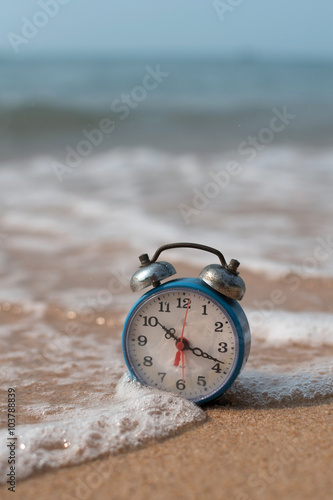 alarm clock on sand beach