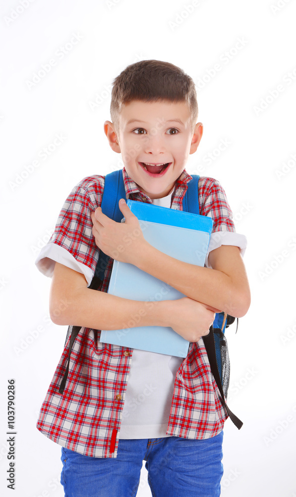 Happy little boy with back pack holding books, isolated on white Happy little boy with back pack holding books, isolated on white