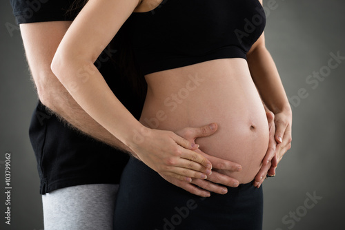 Male Hand Over Pregnant Woman Belly