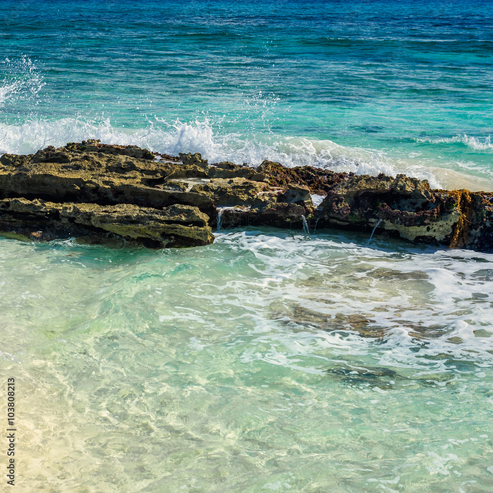 Rock on tropical beach and clear water of the turquoise sea. Car
