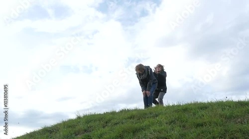 Two friends playing leapfrog down the hill 