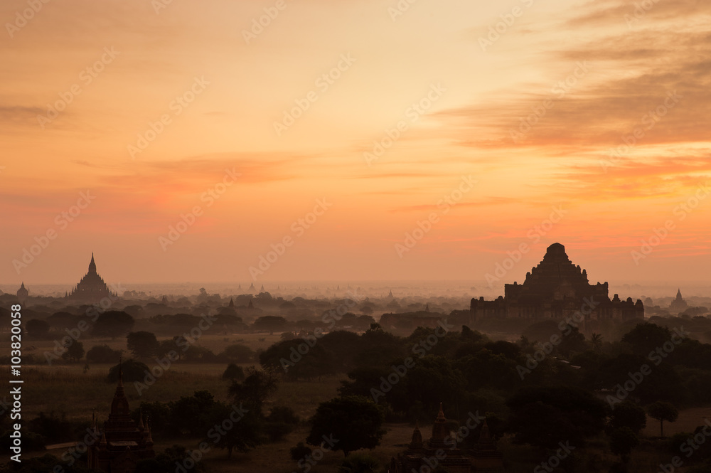Hot air balloon float over silhouette ancient temple with scenic sunrise orange sky background at Old Bagan , Myanmar