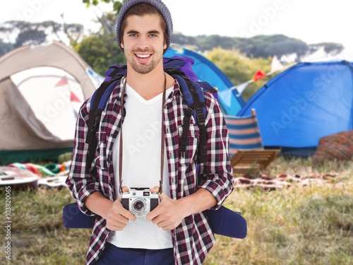 Composite image of portrait of happy man holding camera