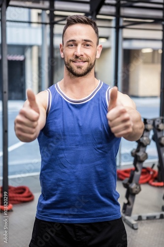 Muscular man showing thumbs up