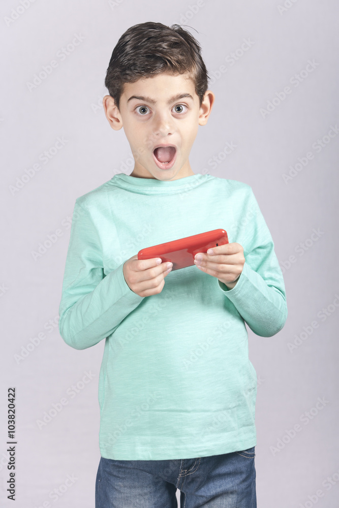 Little boy reacts while using a smart phone Little boy reacts while using a smart phone
