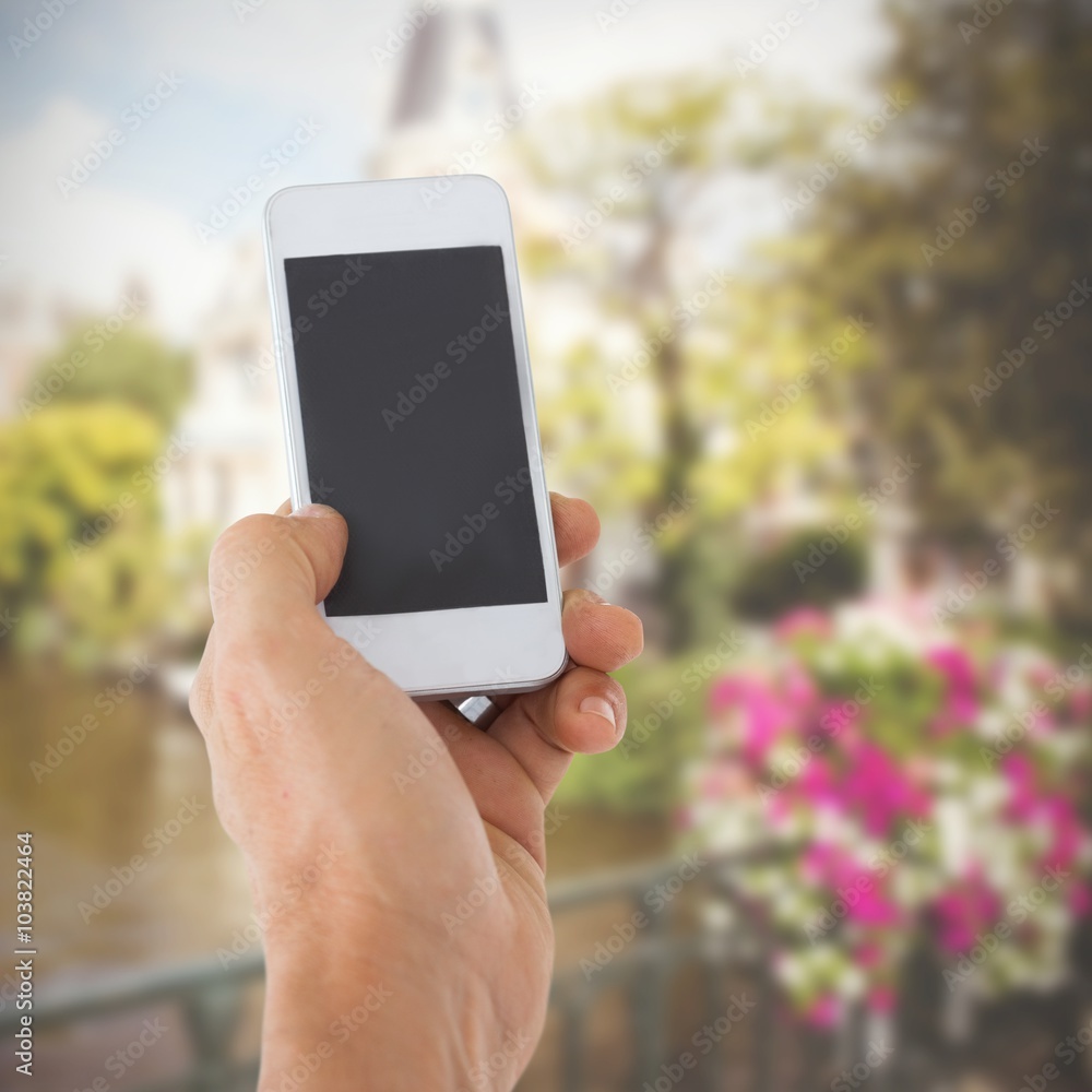 Composite image of male hand holding a smartphone