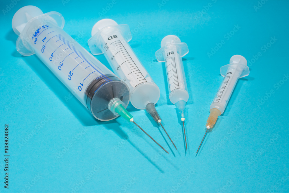 syringes on a blue background, round, sorted by size - obrazy, fototapety, plakaty 