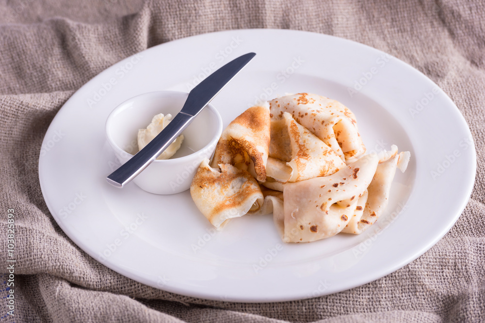 Closeup dish with pancakes and knife and butter Closeup dish with pancakes and knife and butter