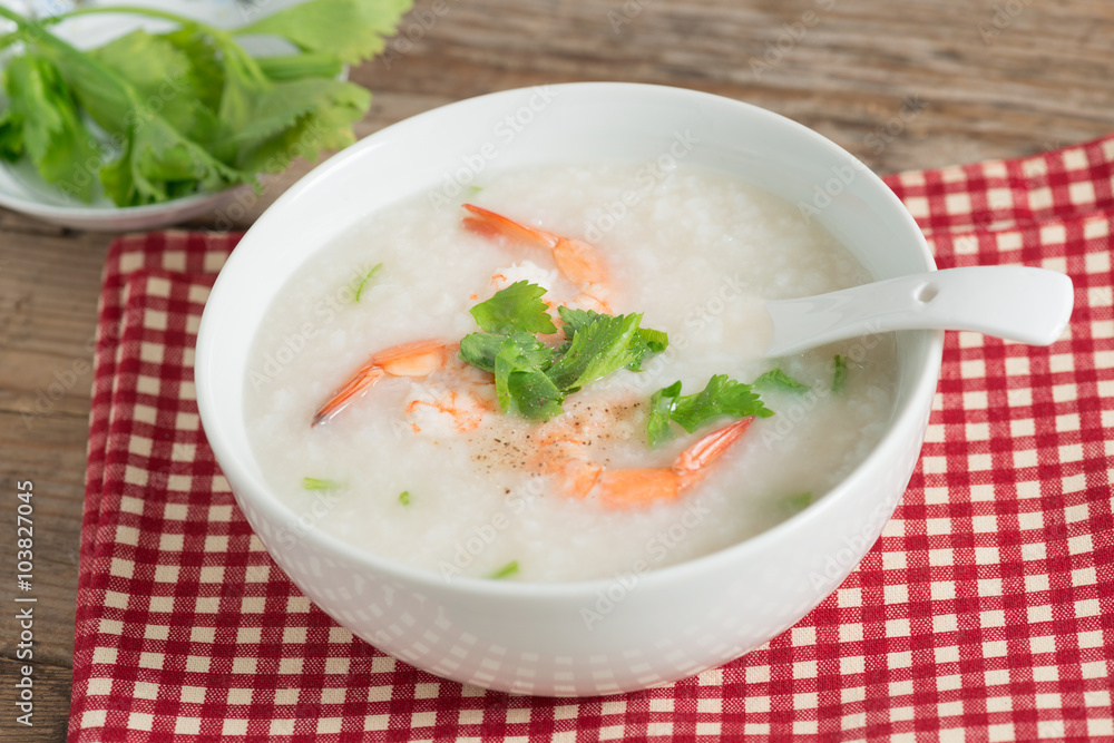 Rice porridge with shrimp in white bowl.