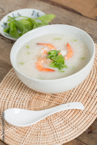 Rice porridge with shrimp in white bowl.
