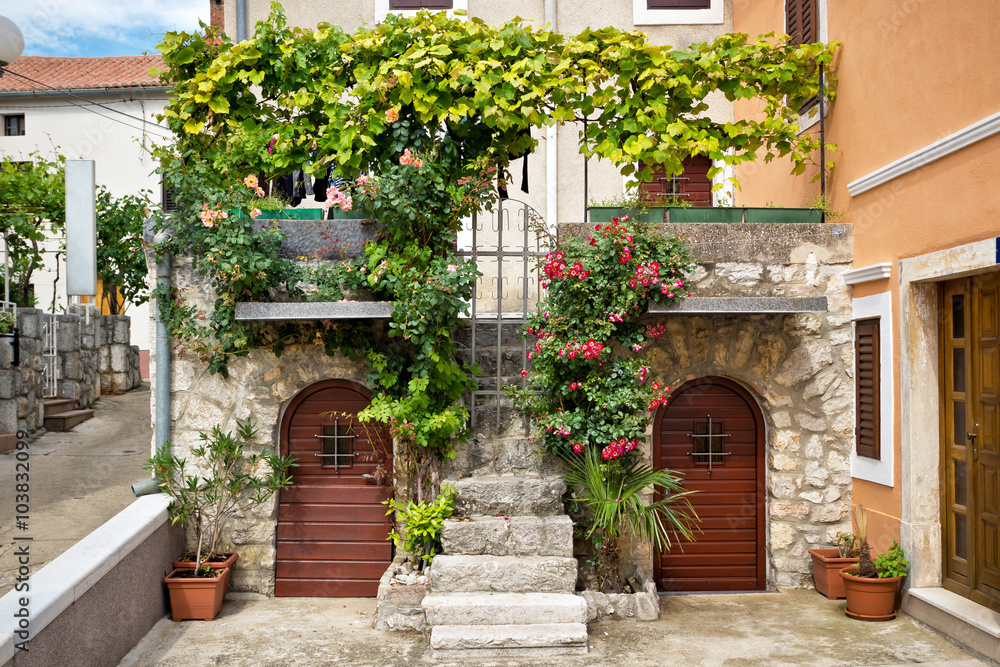 Fototapeta premium Doors and balconies full of of green plants and flowers in a traditional mediterranean house