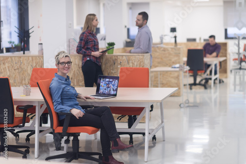 portrait of young business woman at office with team in backgrou