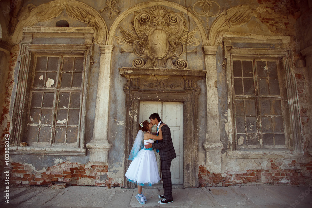 groom kissing his bride on background old castle