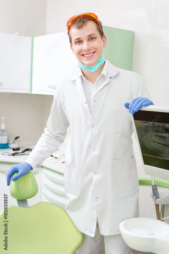 Young Dentist standing in dental surgery Young Dentist standing in dental surgery