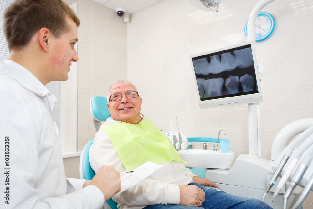 Elderly man on a review of a dentist, sitting in a chair Elderly man on a review of a dentist, sitting in a chair