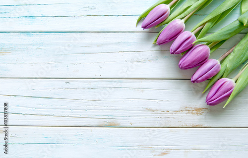 Purple tulips on wooden bac...