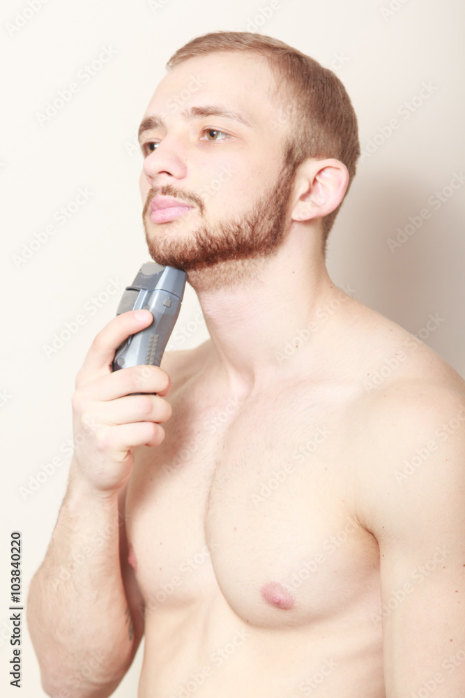 Fototapeta premium bearded guy shave electric razor