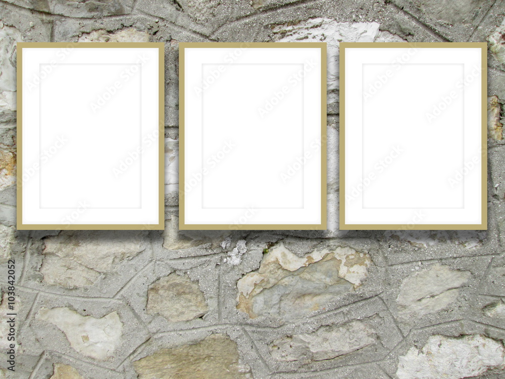 Naklejka premium Close-up of three beige picture frames on old stone wall background