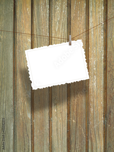 Close-up of one hanged postcard on vertical wooden boards background