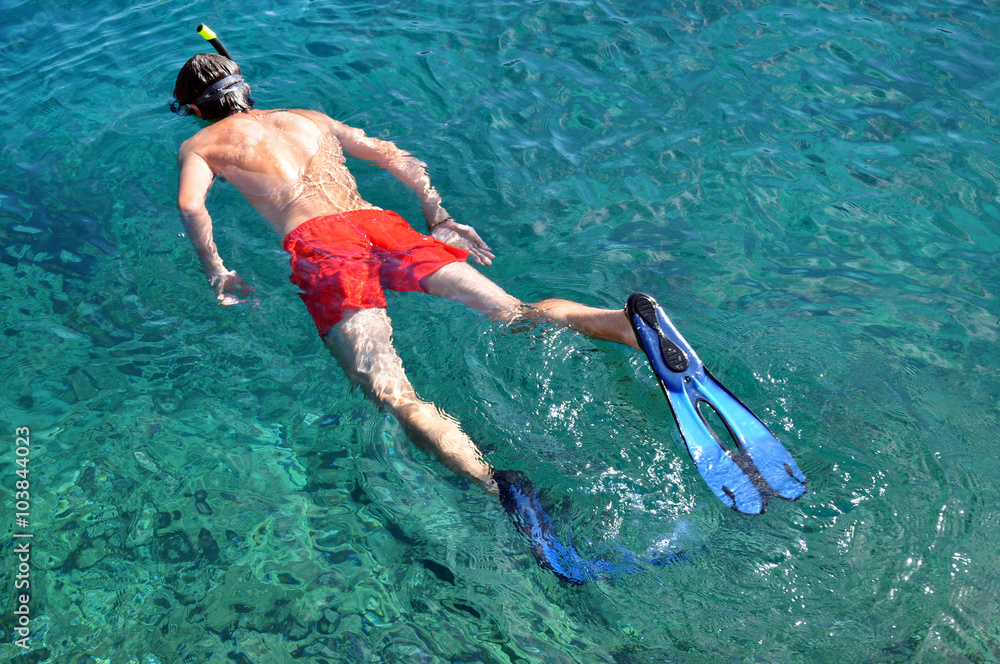 Man snorkeling in a tropical sea over a coral reef