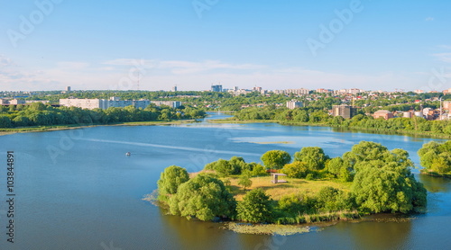 Top view of the river island in the middle of the river and the city on the shore