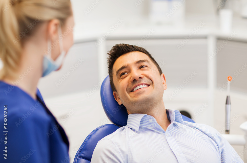 Fototapeta premium female dentist with happy male patient at clinic