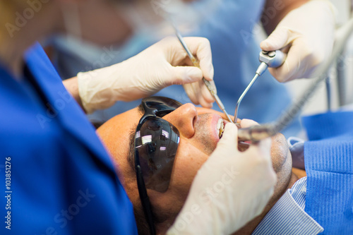 close up of dentists treating teeth at clinic