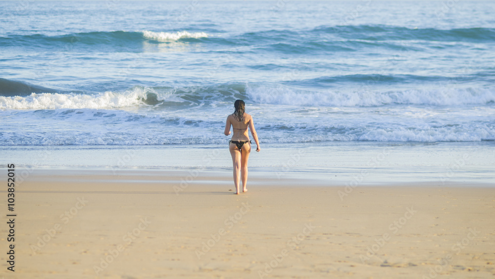 Mujer caminando por la orilla de la playa