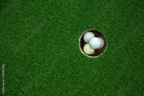 Top view of golf balls stacked up in green field