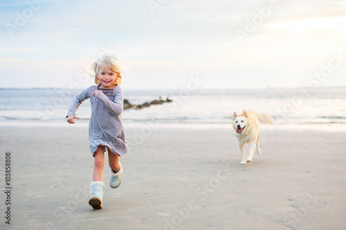 Little Girl and Dog running on the beach
