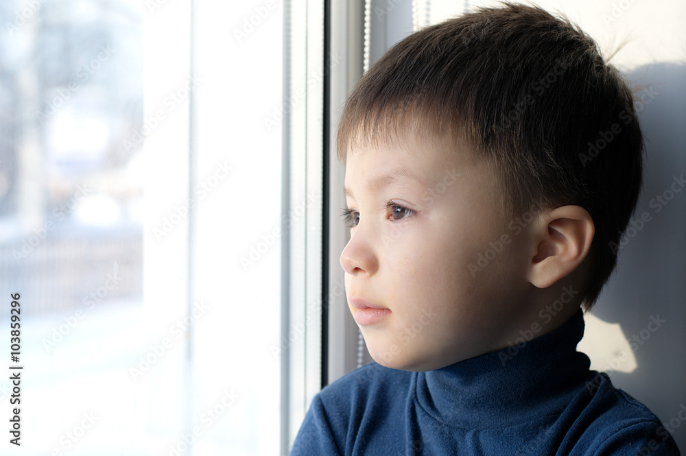 Boy looking out the window and thinking philosophical