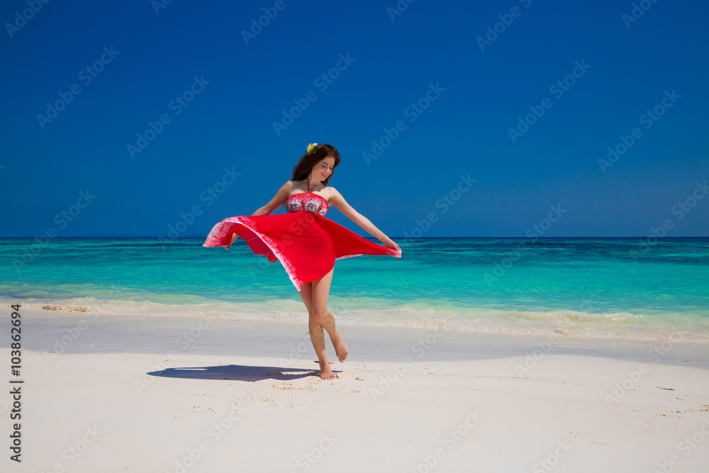 Beautiful happy woman dancing enjoying on exotic beach in summer