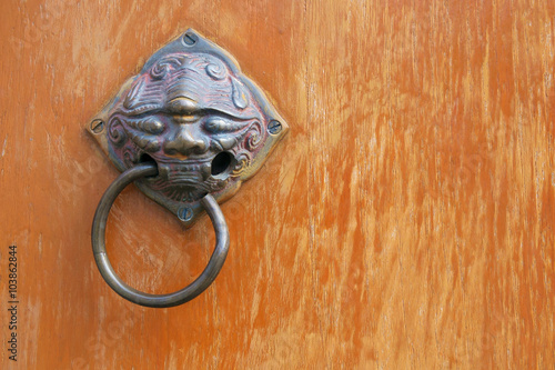 Doorknob / Old rusty brass doorknob evil head shape on wood door.