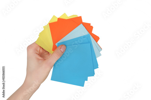 Woman hand holding colorful paper stickers on white background