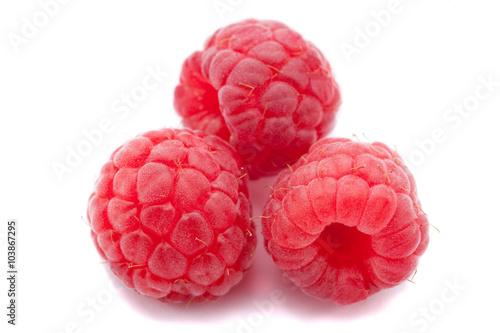 Three fresh raspberry isolated over white background. Close up macro shot.