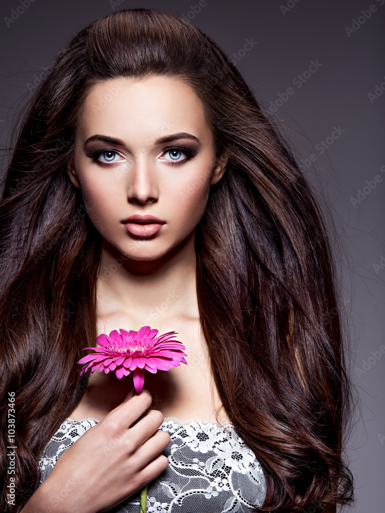Naklejka premium Portrait of beautiful young woman with long brown hair with pi