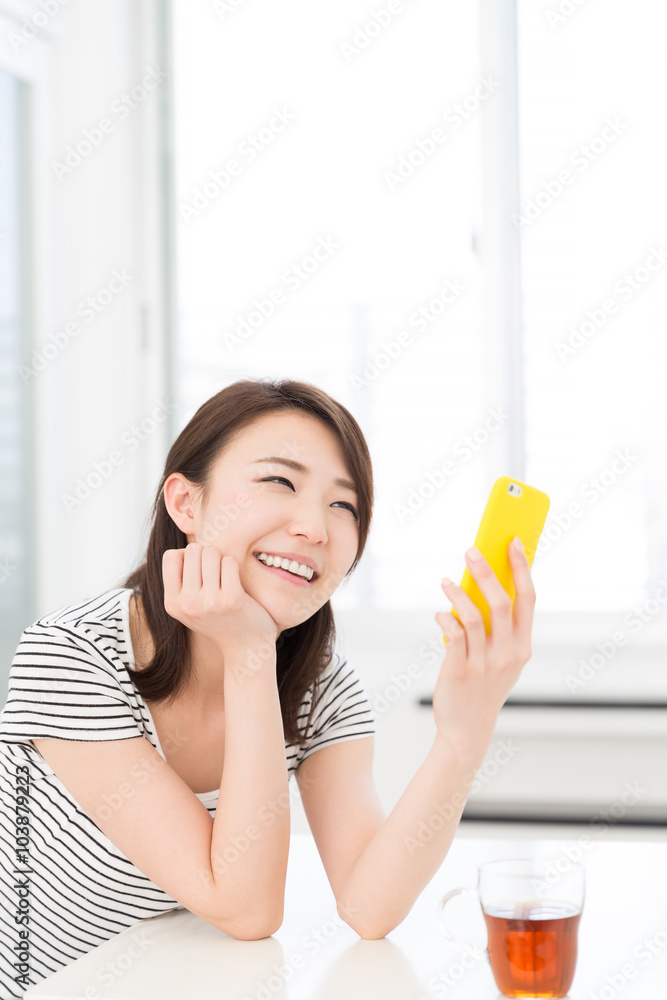 部屋でスマホを見る女性 部屋でスマホを見る女性