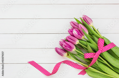 Fototapeta Naklejka Na Ścianę i Meble -  Bouquet of bright pink tulips on white wooden background. Top view, copy space