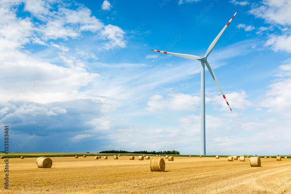 Windmill on the wheat field with hay bales Windmill on the wheat field with hay bales