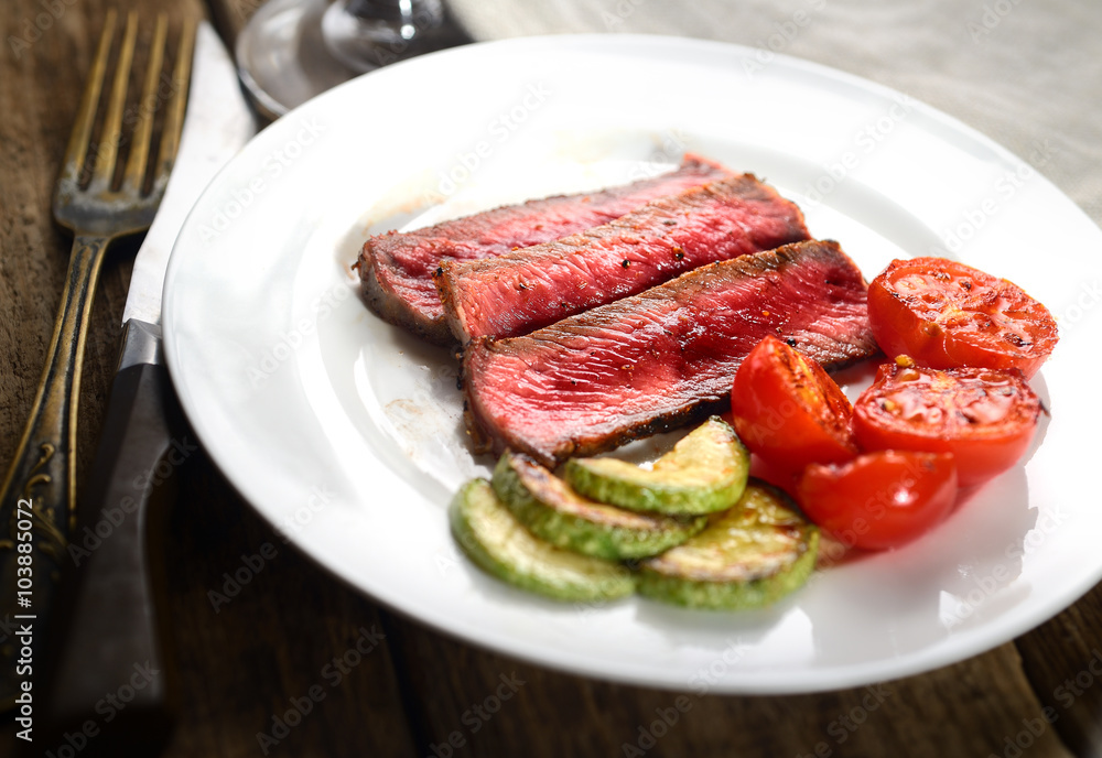 slices of steak with tomato and green sauce slices of steak with tomato and green sauce