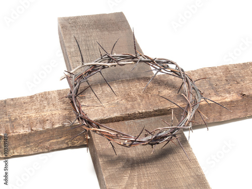 Crown of thorns on a wooden cross isolated on white photo