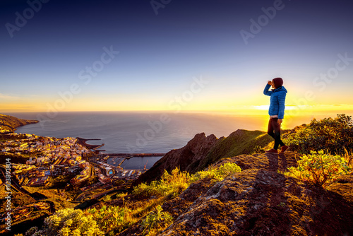 Foto Young female traveler in blue jacket enjoying landscape view on Santa Cruz city