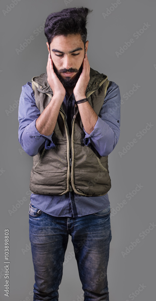 Studio shot of Iraq brunette boy isolated on gray background with epic beard Studio shot of Iraq brunette boy isolated on gray background with epic beard