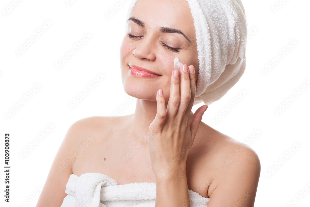 girl in towels applying cream on her face after bath girl in towels applying cream on her face after bath