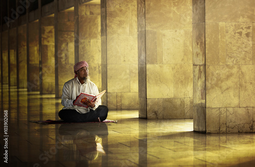 Religious muslim man reading holy koran