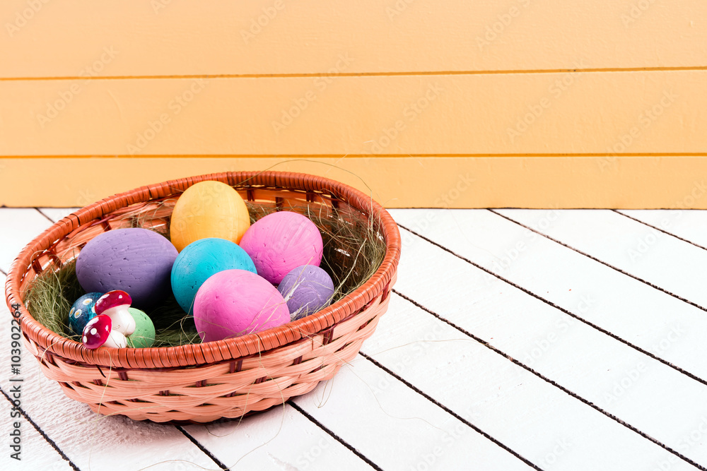 Colorful Easter eggs in basket on a wooden background. Eco-friendly material without violence against animals Colorful Easter eggs in basket on a wooden background. Eco-friendly material without violence against animals