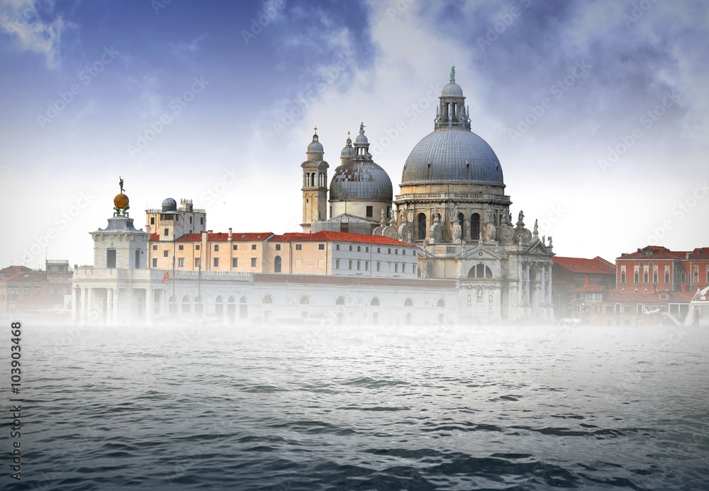Foggy morning in Venice - Italy. Grand canal and Santa Maria della Salute church.